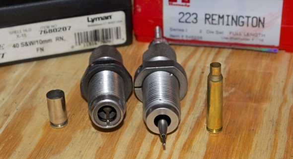 A .40 S&W resizing die (left) Note the carbide ring. The .223 Remington resizing die on the right has the decapping rod extended to show the case mouth expander ball.